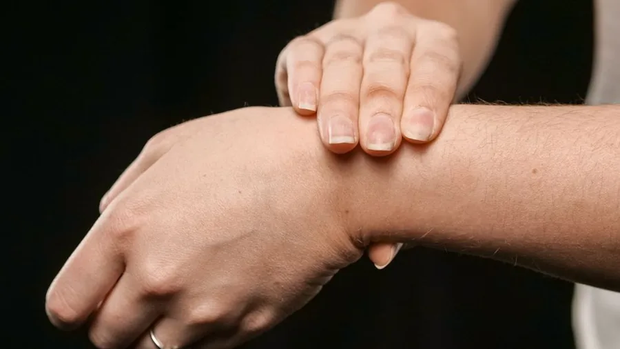 양손으로 반대쪽 손목을 감싸 쥔 모습